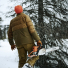 Filson Down Cruiser Jacket Dark Tan men with chainsaw in the snow