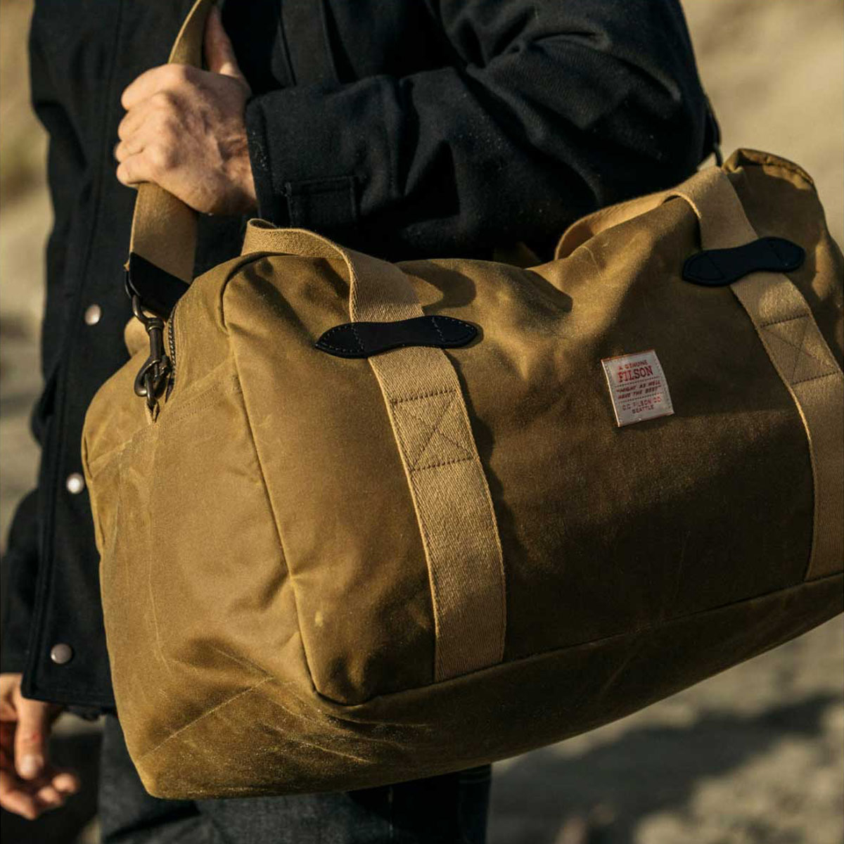 Filson Tin Cloth Medium Duffle Bag Dark Tan, is uitermate geschikt voor een weekendje weg of een avontuurlijke reis